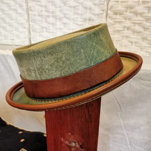 Weathered turquoise (after weathering) and brown handmade leather pork pie hat by Be Savage Crafted