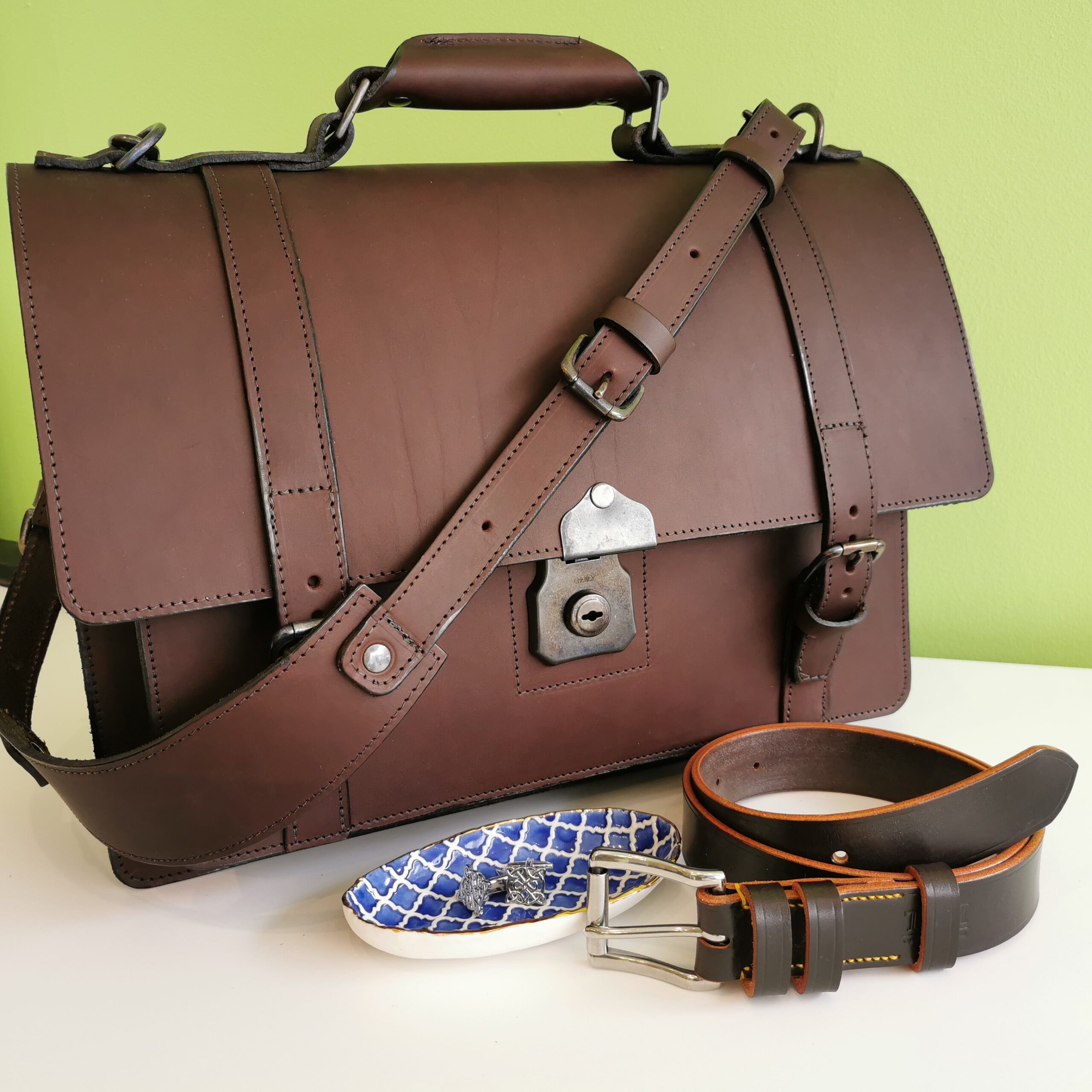 Brown and silver group picture of: The Full Monty briefcase, Dark Havana leather belt, Blue Alhambra porcelain trinket tray and Celtic Knot cufflinks